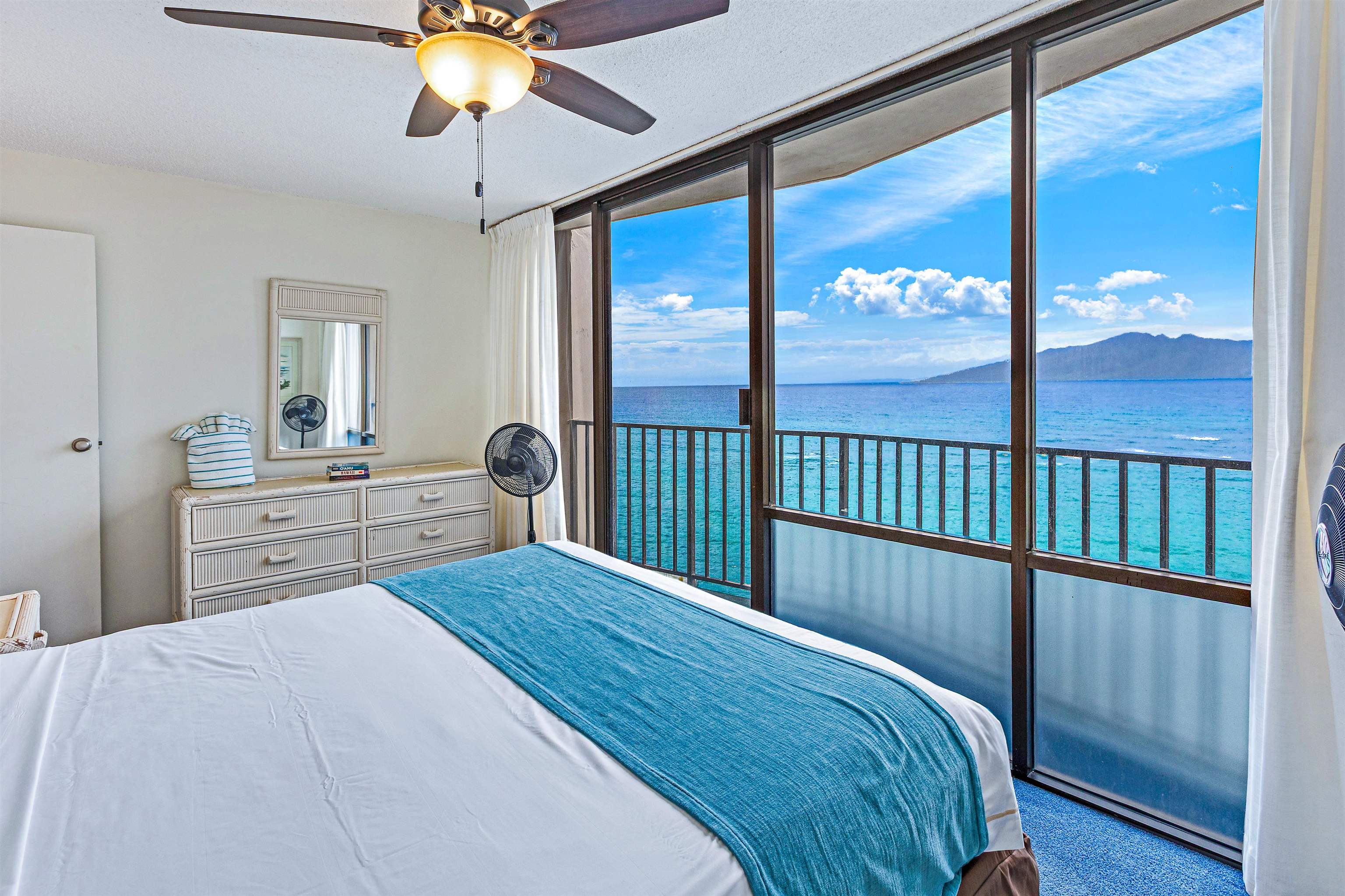 4327 Lower Honoapiilani Road, Unit 808 Lahaina, HI 96761 - Photo 8 of 35 a bedroom with a large bed and a chandelier
