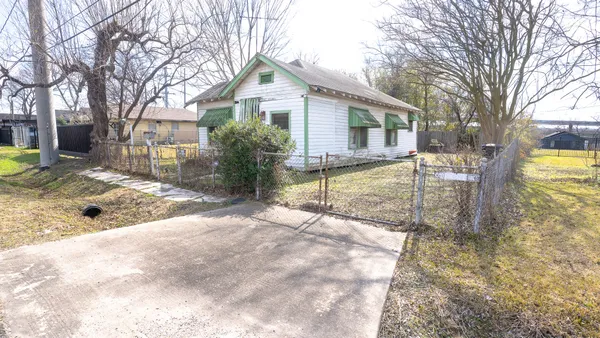 a view of a house with backyard and trees