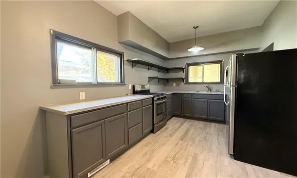 a kitchen with a sink appliances cabinets and a counter top space