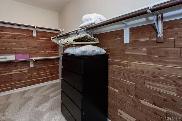 a bedroom with a large bed and a chandelier fan