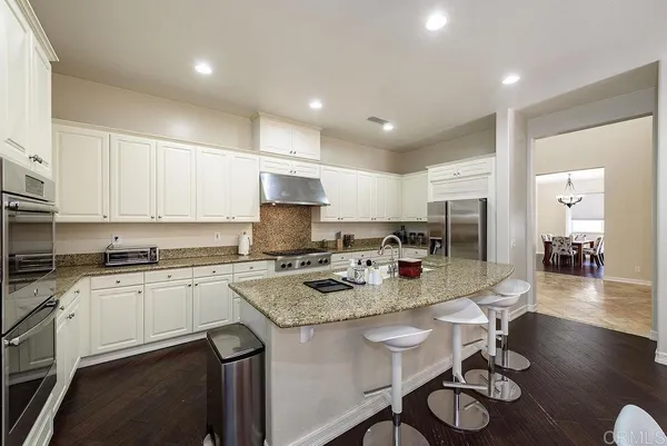 a kitchen with granite countertop white cabinets and white appliances