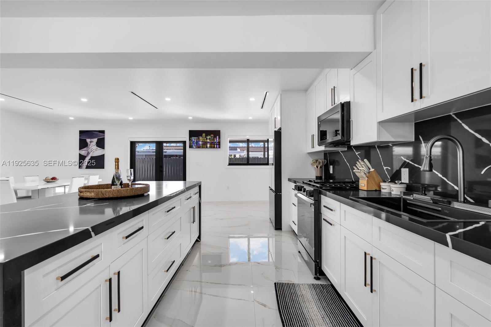 864 West 69th Place Hialeah, FL 33014 - Photo 12 of 45 a kitchen with stainless steel appliances granite countertop a sink and cabinets