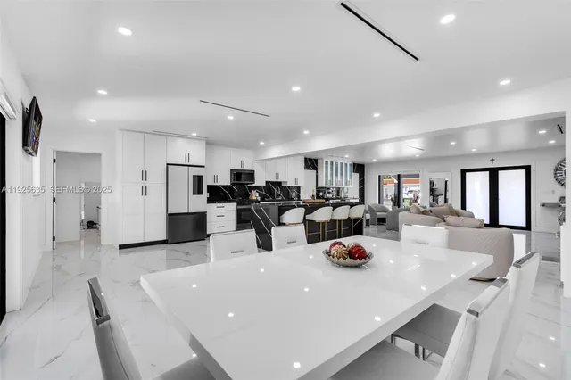 a kitchen with a sink a refrigerator and chairs