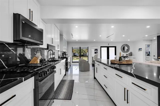 a large kitchen with stainless steel appliances lots of counter space and a sink