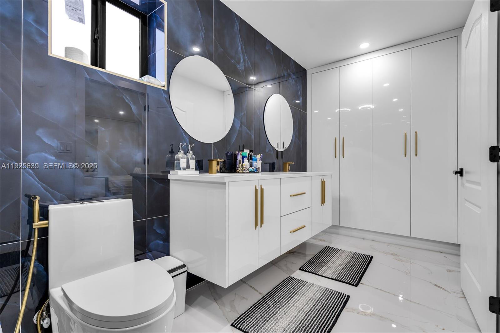 864 West 69th Place Hialeah, FL 33014 - Photo 26 of 45 a bathroom with a toilet a sink a mirror and vanity