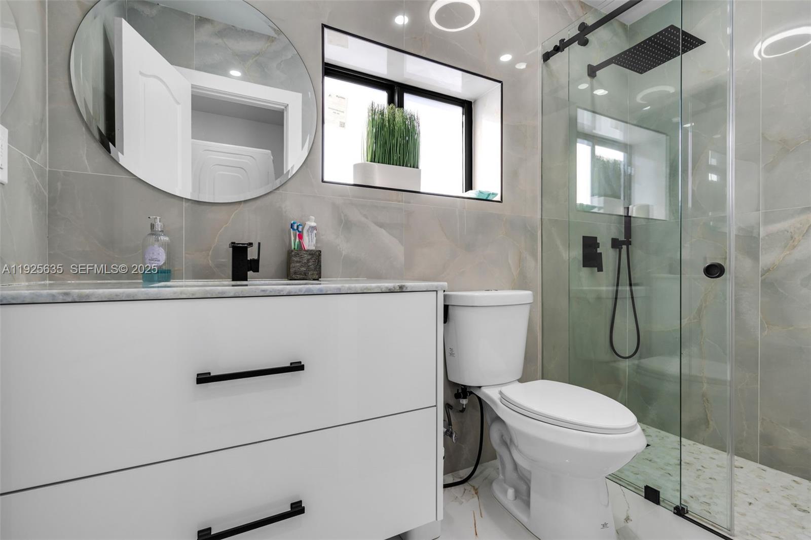 864 West 69th Place Hialeah, FL 33014 - Photo 29 of 45 a bathroom with a toilet sink vanity shower and mirror