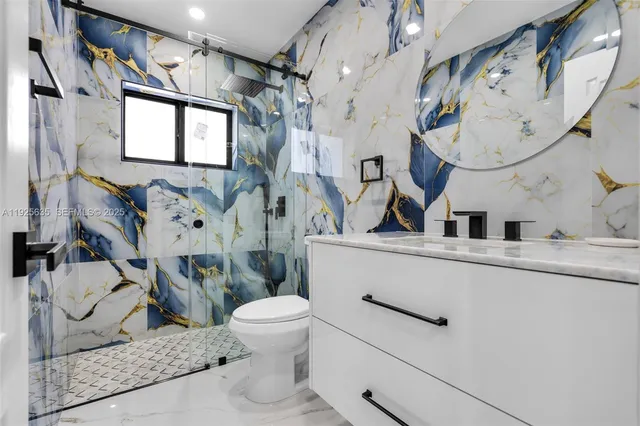 a bathroom with a sink mirror vanity and toilet