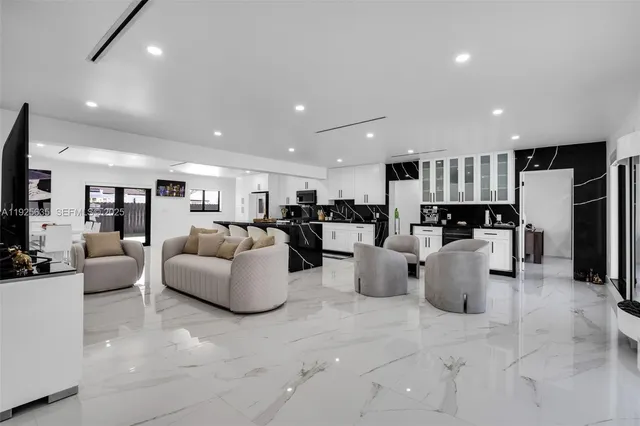 a living room with lots of furniture and kitchen view
