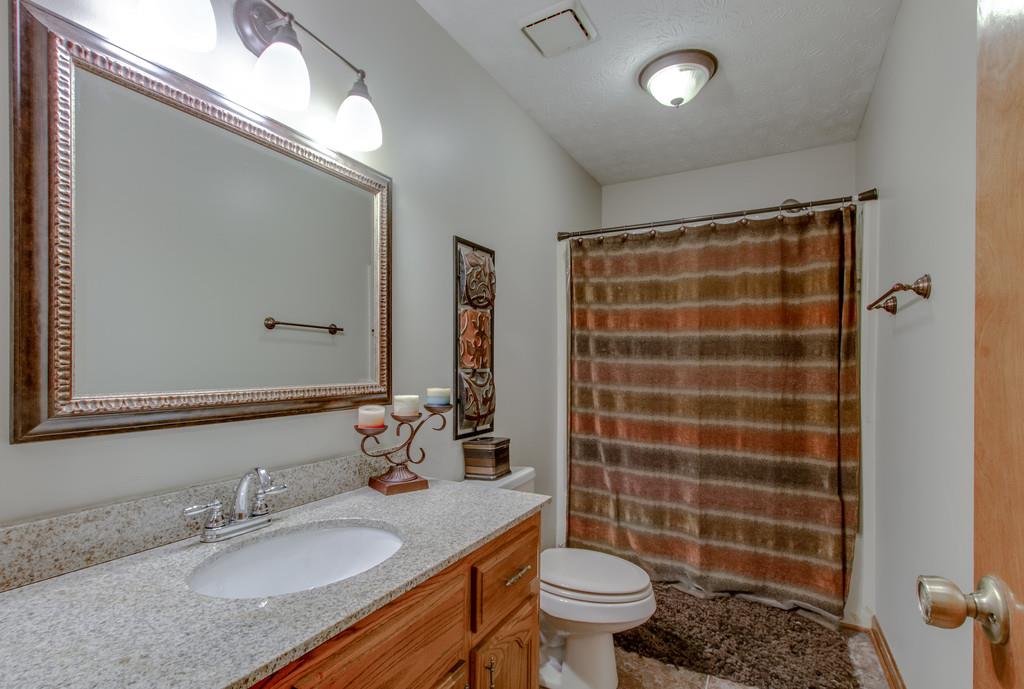 4002 Harding Place Springfield, TN 37172 - Photo 13 of 17 a bathroom with a granite countertop sink a toilet a mirror and shower