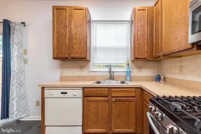 a kitchen with stainless steel appliances a stove a sink and a microwave