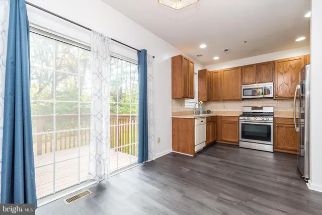 a kitchen with a white cabinets and wooden floor