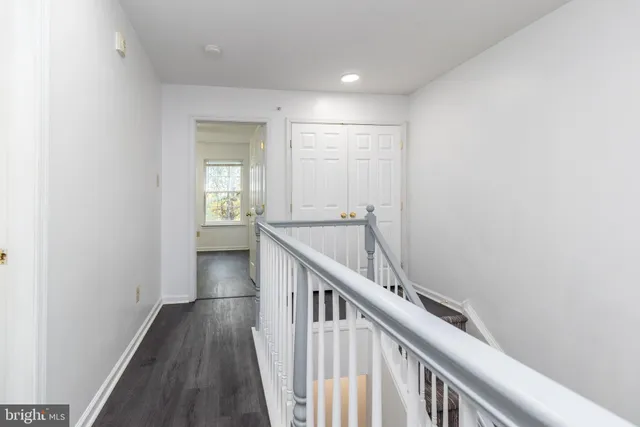 a view of a hallway with wooden floor and stairs