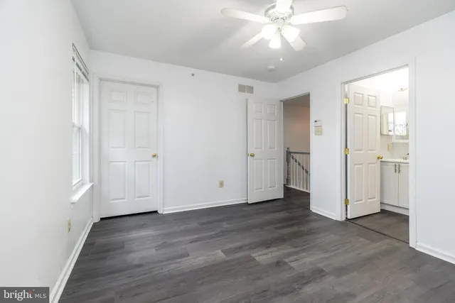 an empty room with wooden floor and ceiling fan