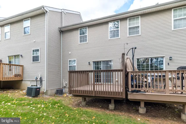 a view of a house with a wooden deck and a yard