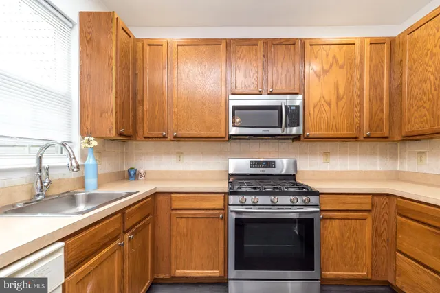 a kitchen with stainless steel appliances wooden cabinets and a stove top oven