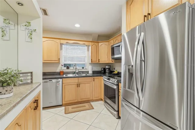 a kitchen with stainless steel appliances granite countertop a sink and white cabinets