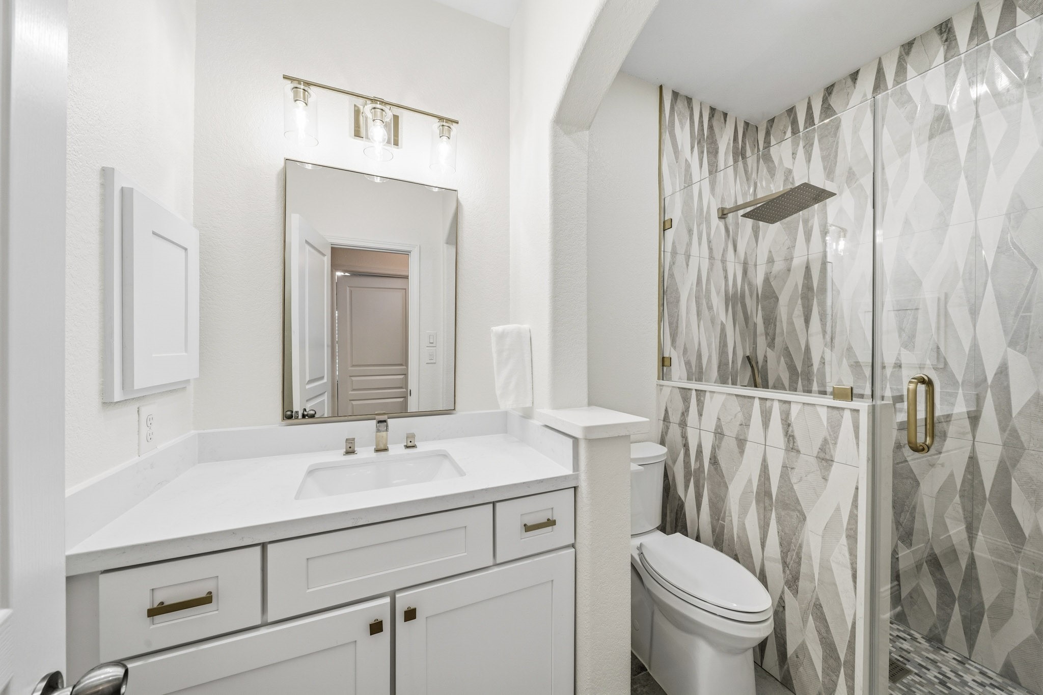 17610 Strackfield Lane Tomball, TX 77377 - Photo 37 of 50 The third bath has been beautifully reimagined with oversized 12x24 tile floors, quartz counters, and a stunning floor-to-ceiling tiled shower featuring a rain head and separate spray wand for a spa-inspired experience.