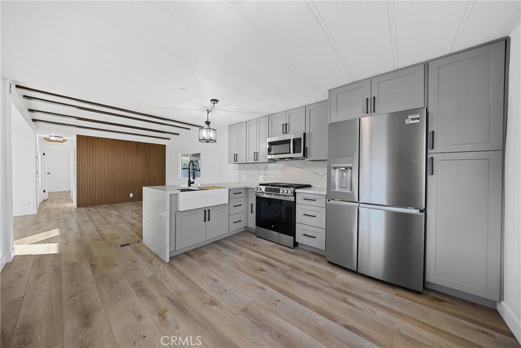 1255 Amethyst Street, Unit 51 Mentone, CA 92359 - Photo 2 of 60 a kitchen with a refrigerator a sink and a stove top oven