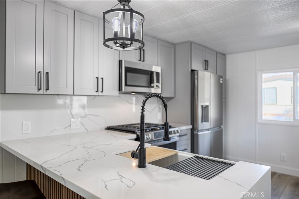 1255 Amethyst Street, Unit 51 Mentone, CA 92359 - Photo 47 of 60 a kitchen with stainless steel appliances a sink a refrigerator and microwave