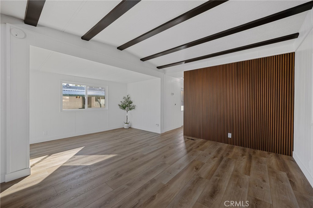 1255 Amethyst Street, Unit 51 Mentone, CA 92359 - Photo 6 of 60 a view of an empty room with wooden floor and a window