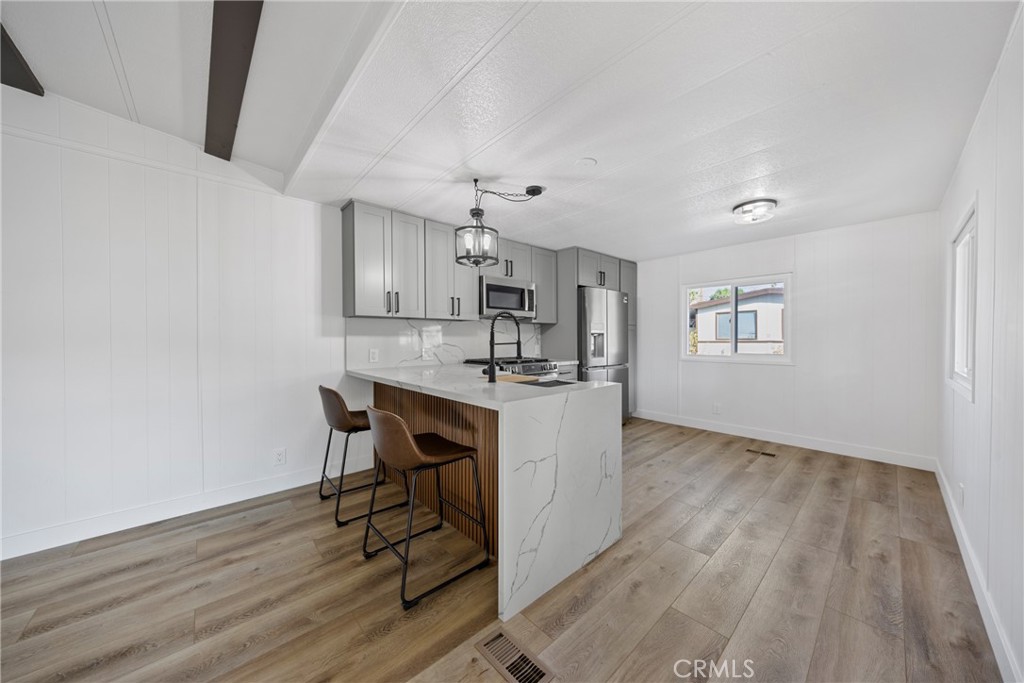 1255 Amethyst Street, Unit 51 Mentone, CA 92359 - Photo 7 of 60 a kitchen with kitchen island white cabinets and stainless steel appliances