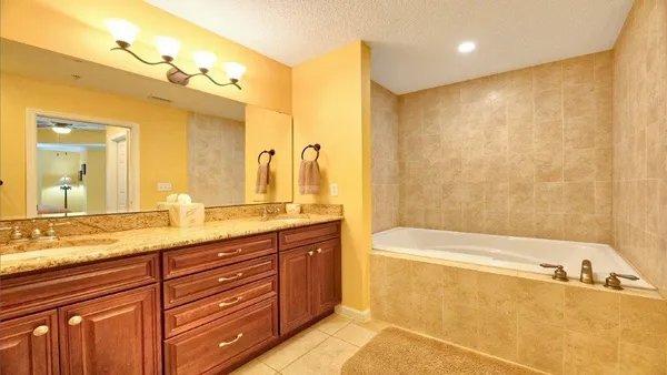 a bathroom with a granite countertop sink and a bathtub