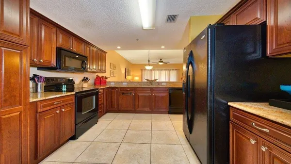 a kitchen with stainless steel appliances granite countertop a refrigerator and a stove top oven