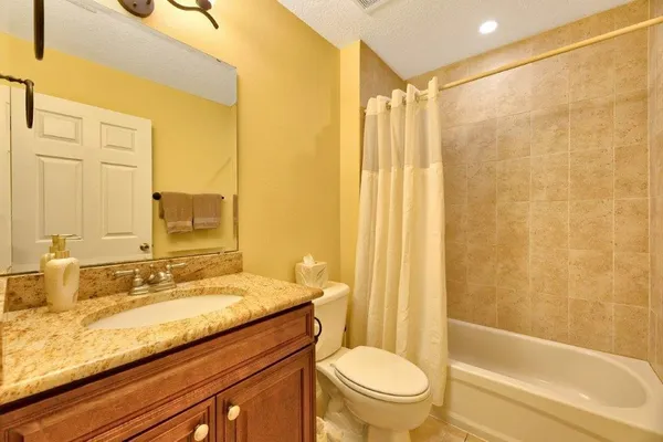 a bathroom with a granite countertop sink toilet and shower