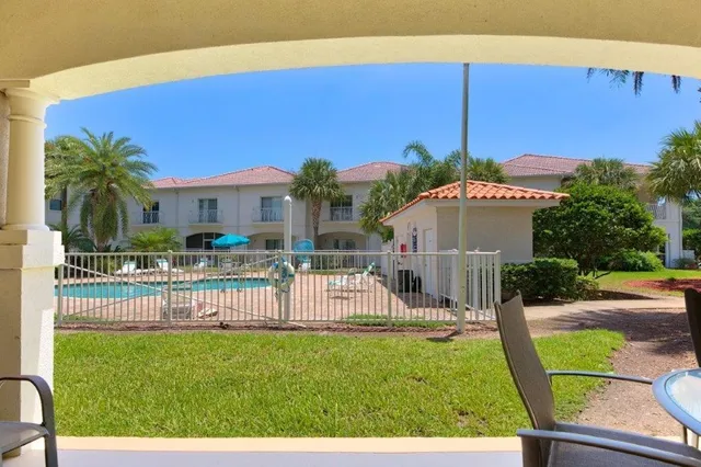 a view of a house with backyard and sitting area