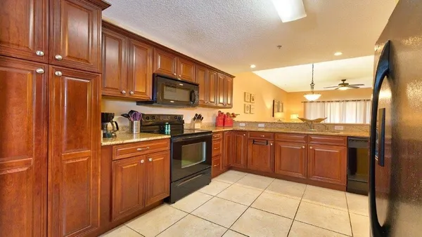 a kitchen with stainless steel appliances granite countertop a refrigerator and wooden cabinets