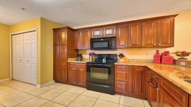 a kitchen with stainless steel appliances granite countertop a refrigerator stove and sink