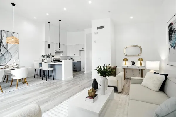 a living room with furniture a rug and white walls
