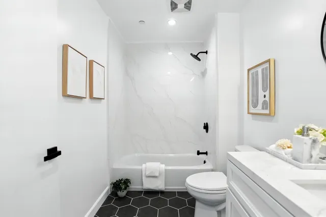 a bathroom with a sink a toilet and shower