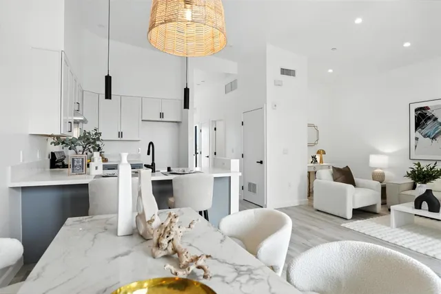 a kitchen with stainless steel appliances kitchen island granite countertop a table and chairs in it