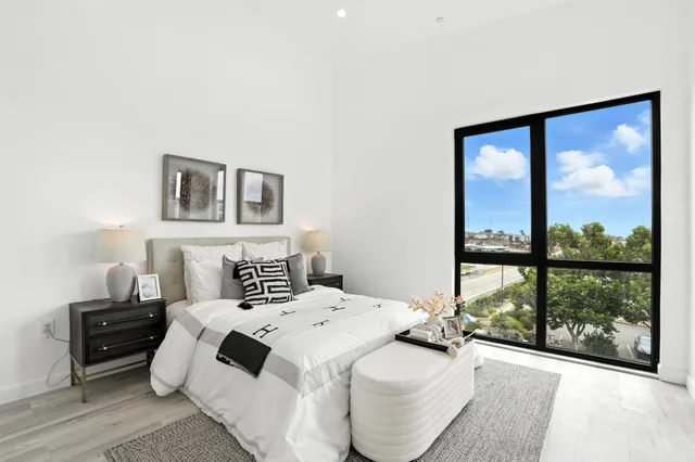 a bedroom with a bed and a large window