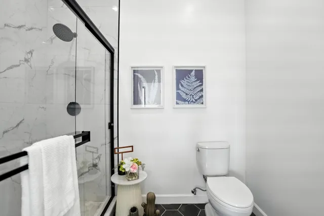 a bathroom with a granite countertop sink a toilet and shower