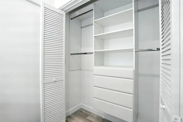a view of walk in closet with empty racks