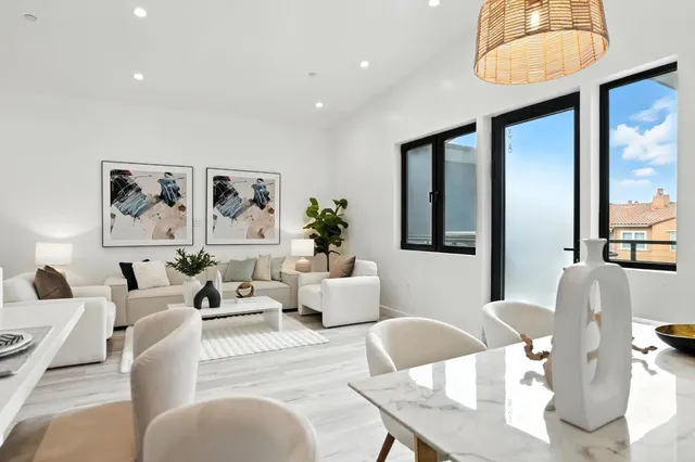 a living room with furniture a large window and wooden floor