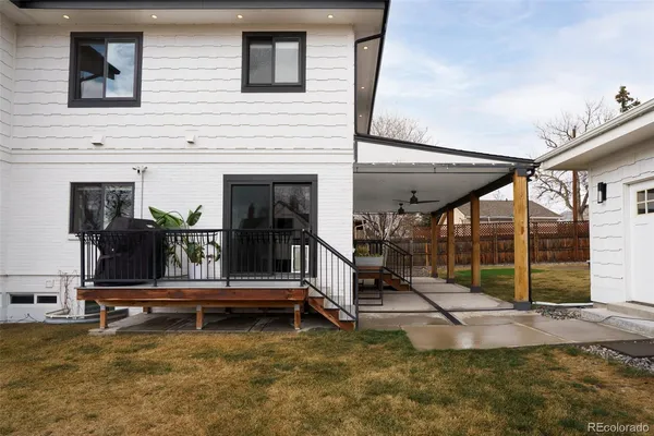 a view of a house with large windows and a small yard