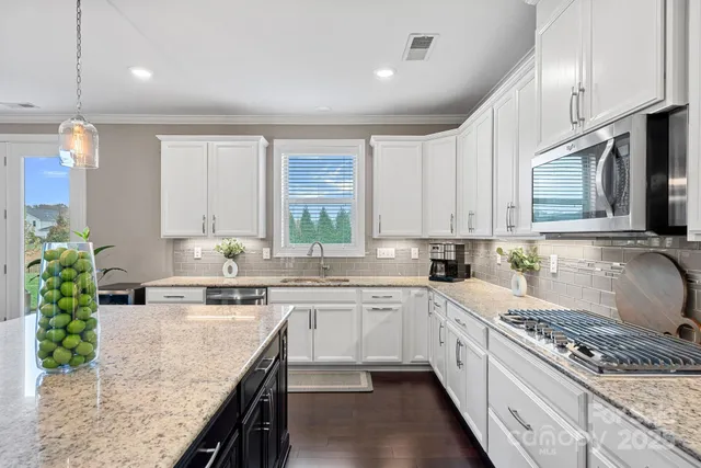 a large kitchen with stainless steel appliances granite countertop a sink stove and refrigerator