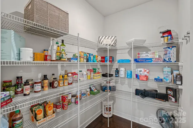 a room with stainless steel appliances a white wooden floor and a shelf