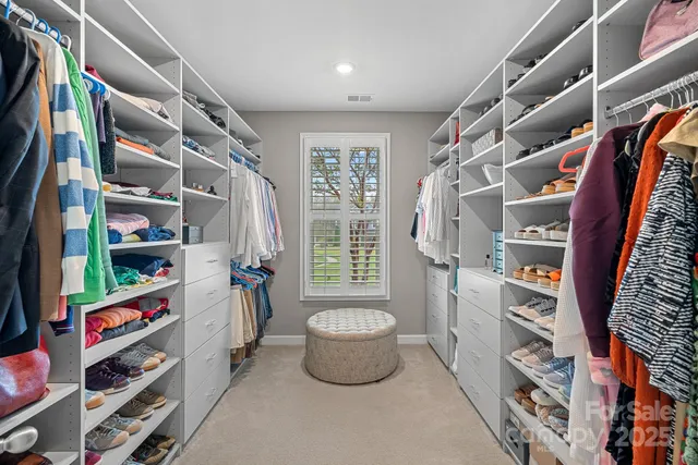 a view of walk in closet with clothes and shoes