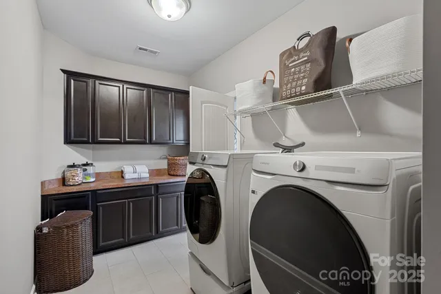 a utility room with cabinets dryer and washer