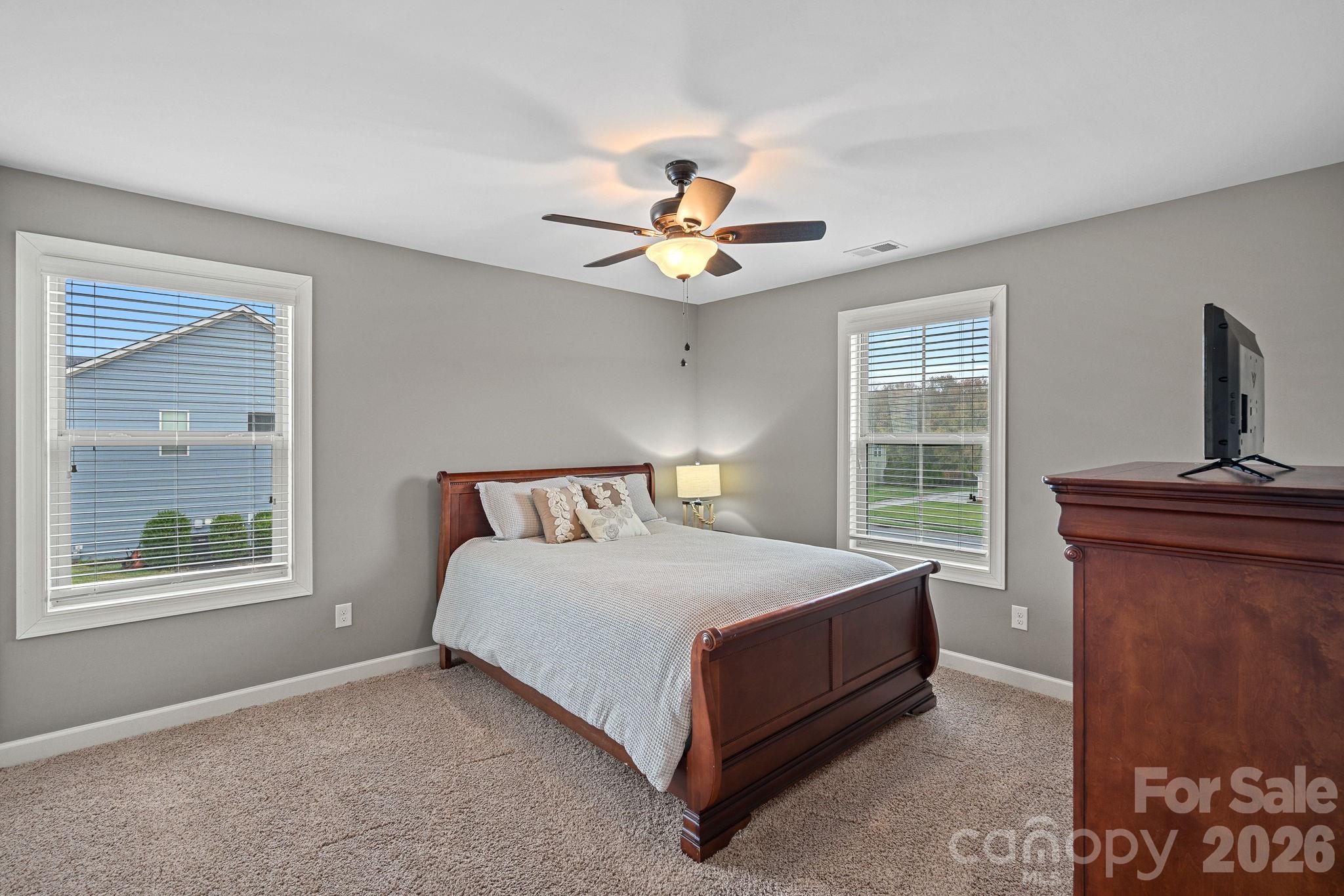 706 Blaise Court Matthews, NC 28104 - Photo 34 of 48 a bedroom with a bed and a chandelier