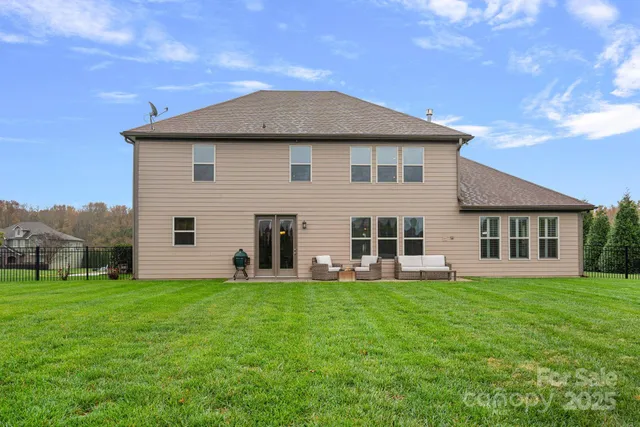 a backyard of a house with table and chairs