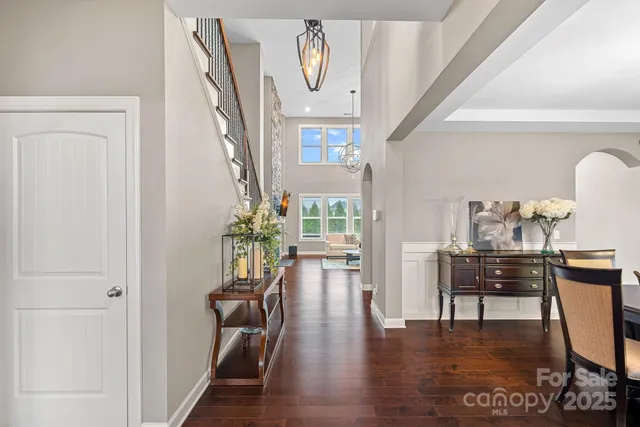 a view of a hallway with wooden floor table and windows