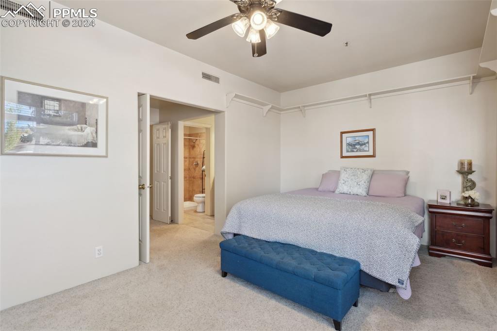175 West Cheyenne Road, Unit 214 Colorado Springs, CO 80906 - Photo 11 of 28 a spacious bedroom with a bed and a chandelier
