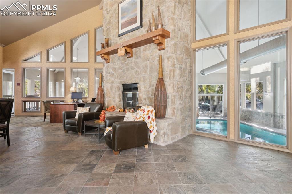 175 West Cheyenne Road, Unit 214 Colorado Springs, CO 80906 - Photo 21 of 28 a living room with furniture a fireplace and a floor to ceiling window
