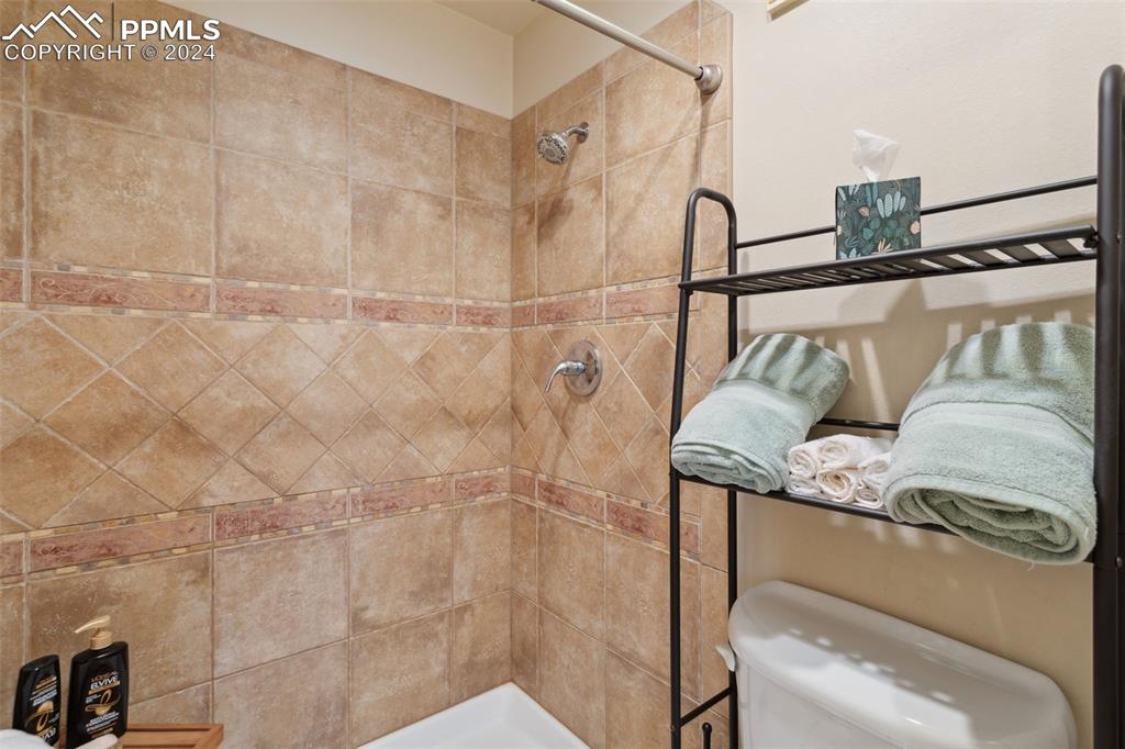 175 West Cheyenne Road, Unit 214 Colorado Springs, CO 80906 - Photo 26 of 28 a bathroom with a granite countertop sink a mirror and shower