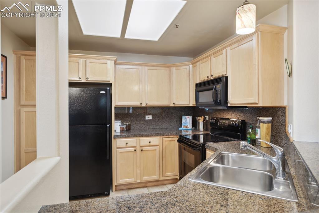 175 West Cheyenne Road, Unit 214 Colorado Springs, CO 80906 - Photo 8 of 28 a kitchen filled a sink a microwave a refrigerator and cabinets
